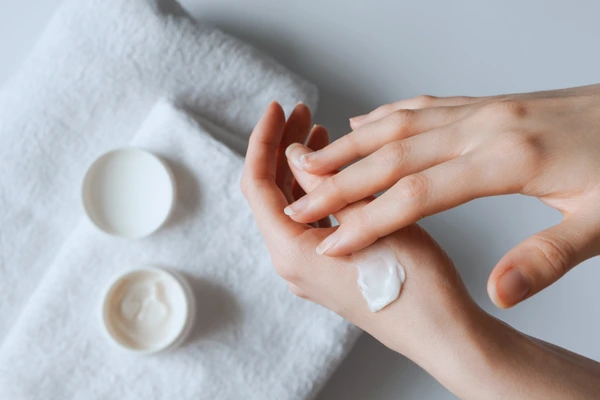 Hands applying moisturiser—hydrating the skin barrier during an eczema flare-up