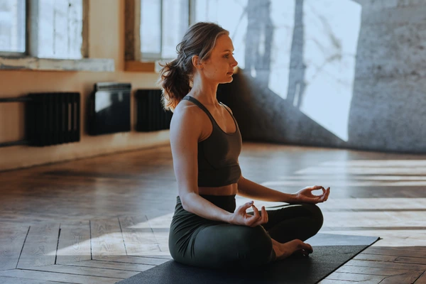 Woman meditating to manage stress—stress can trigger eczema flare-ups