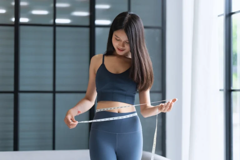 Woman measuring waist—stubborn weight loss in Dubai may be linked to food intolerance